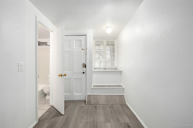 interior space with baseboards and wood finished floors