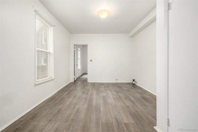 unfurnished room featuring baseboards and wood finished floors