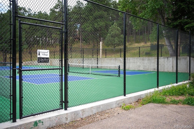 view of sport court with a gate and fence
