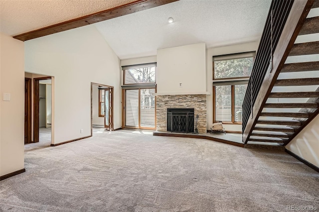 unfurnished living room with carpet floors, beam ceiling, a fireplace, a high ceiling, and a textured ceiling