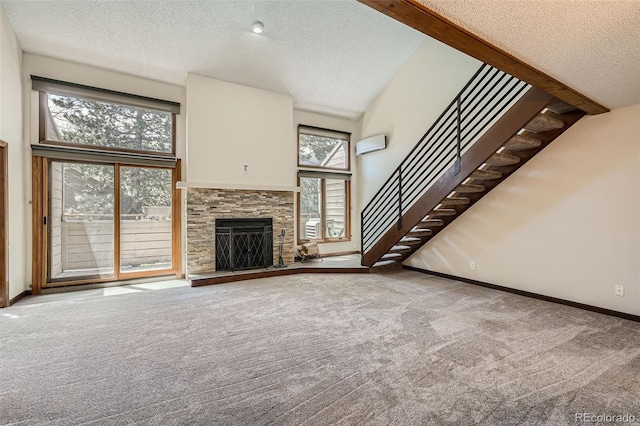 unfurnished living room with stairs, a textured ceiling, a stone fireplace, and carpet