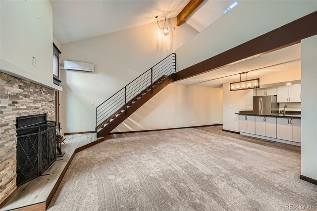unfurnished living room featuring beam ceiling, stairway, high vaulted ceiling, an AC wall unit, and carpet flooring