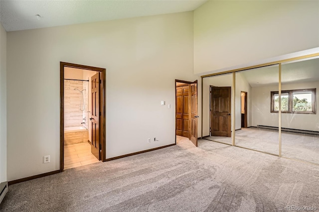 unfurnished bedroom featuring a closet, lofted ceiling, baseboards, a baseboard radiator, and carpet