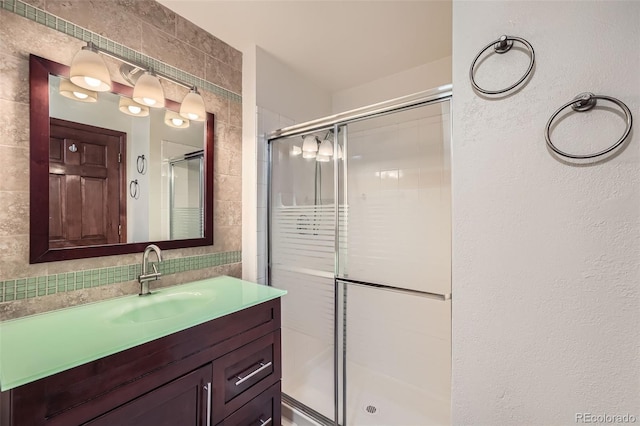 full bathroom featuring vanity, a stall shower, and tile walls