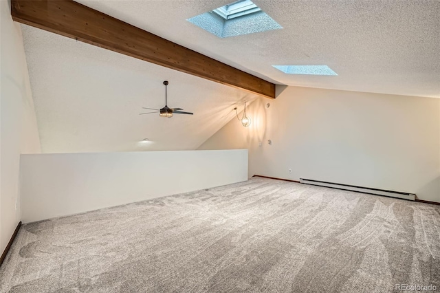bonus room with ceiling fan, baseboard heating, vaulted ceiling with skylight, a textured ceiling, and carpet
