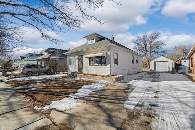 view of front of home with an outdoor structure, a garage, driveway, and a chimney