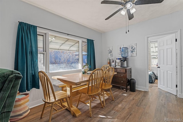 dining space featuring a ceiling fan, wood finished floors, and baseboards