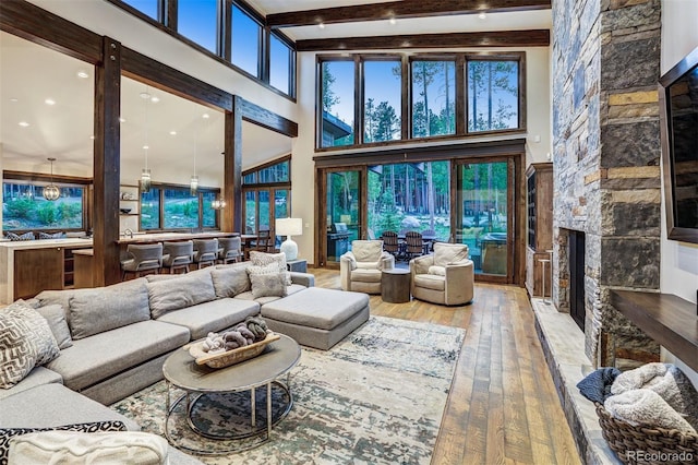141 Sawmill Run Dr, Breckenridge, CO 80424 - living room featuring a fireplace, hardwood / wood-style floors, a towering ceiling, and beam ceiling