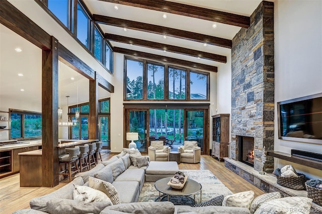 141 Sawmill Run Dr, Breckenridge, CO 80424 - living area featuring light wood-type flooring, a fireplace, beam ceiling, and a towering ceiling