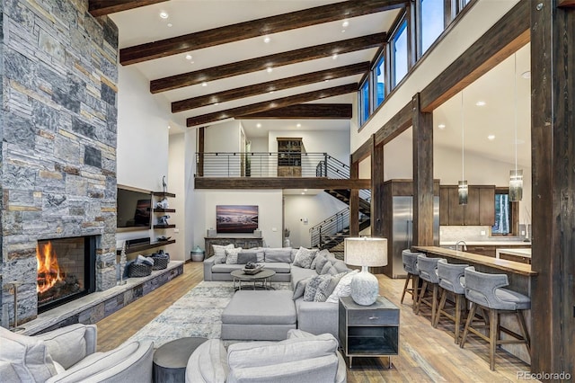 141 Sawmill Run Dr, Breckenridge, CO 80424 - living area with high vaulted ceiling, stairs, a fireplace, beamed ceiling, and light wood-style flooring