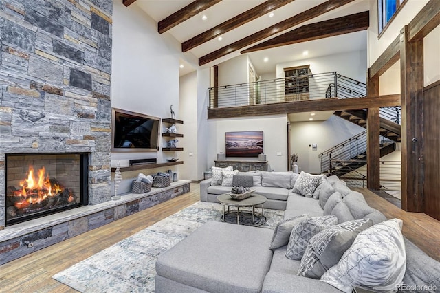 141 Sawmill Run Dr, Breckenridge, CO 80424 - living room featuring a stone fireplace, beam ceiling, stairs, high vaulted ceiling, and wood finished floors