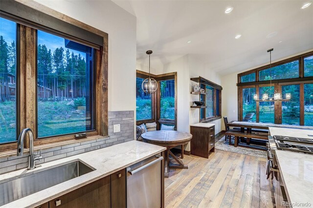 141 Sawmill Run Dr, Breckenridge, CO 80424 - kitchen with dishwasher, light wood-type flooring, light stone countertops, pendant lighting, and dark brown cabinetry