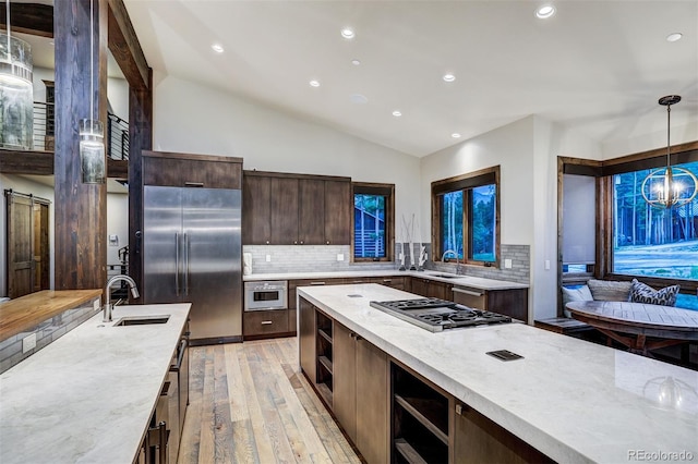 141 Sawmill Run Dr, Breckenridge, CO 80424 - kitchen featuring stainless steel appliances, light wood-style floors, open shelves, dark brown cabinets, and tasteful backsplash