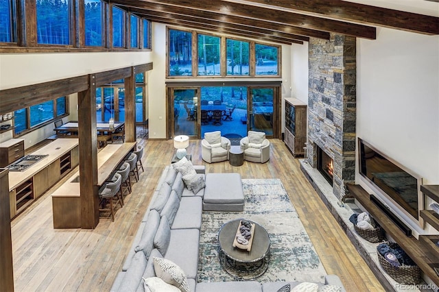 141 Sawmill Run Dr, Breckenridge, CO 80424 - living room featuring beam ceiling, hardwood / wood-style floors, a stone fireplace, and high vaulted ceiling