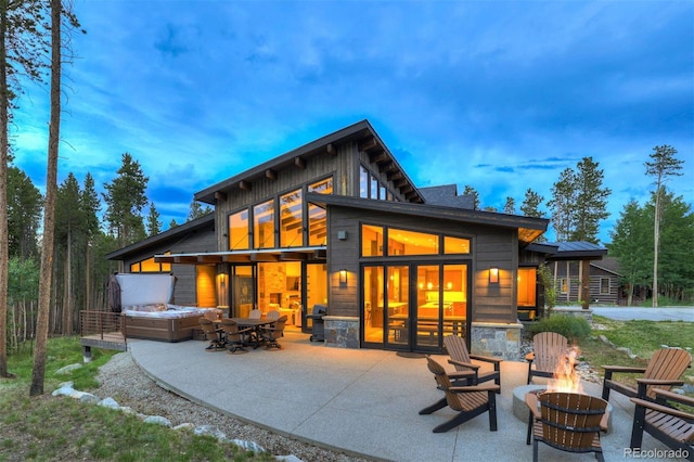 141 Sawmill Run Dr, Breckenridge, CO 80424 - back of property at dusk with a fire pit, a patio area, and stone siding