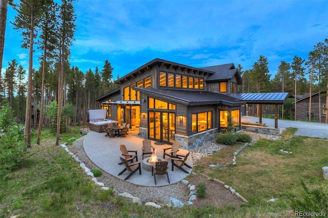 141 Sawmill Run Dr, Breckenridge, CO 80424 - rear view of property with an outdoor fire pit, a standing seam roof, a patio, a lawn, and stone siding