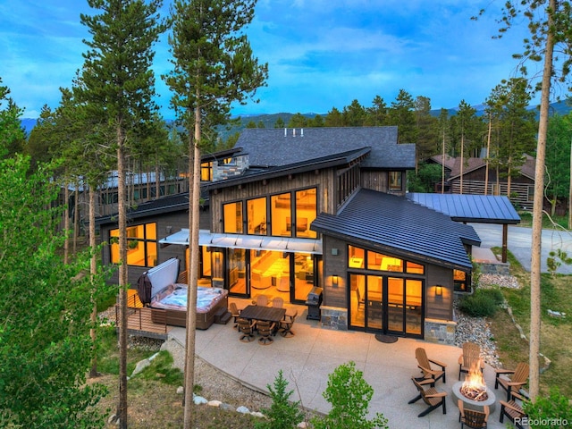 141 Sawmill Run Dr, Breckenridge, CO 80424 - rear view of house with an outdoor fire pit, a standing seam roof, a patio area, and a metal roof