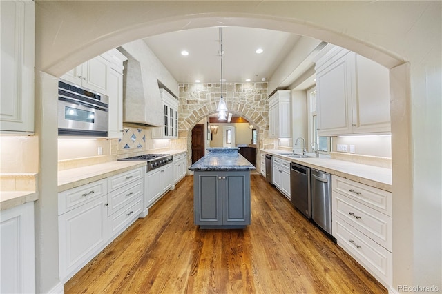 850 E Radcliff Ave, Cherry Hills Village, CO 80113 - kitchen with stainless steel appliances, a center island, white cabinetry, wood finished floors, and recessed lighting