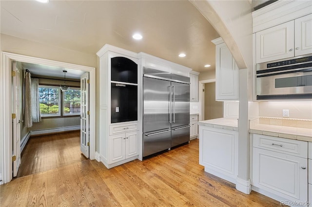 850 E Radcliff Ave, Cherry Hills Village, CO 80113 - kitchen featuring appliances with stainless steel finishes, tile counters, white cabinetry, light wood-style floors, and recessed lighting