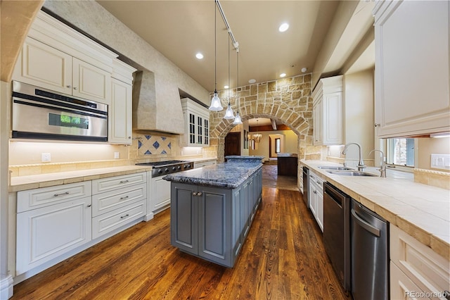 850 E Radcliff Ave, Cherry Hills Village, CO 80113 - kitchen with custom exhaust hood, arched walkways, stainless steel appliances, dark wood-style flooring, and white cabinets