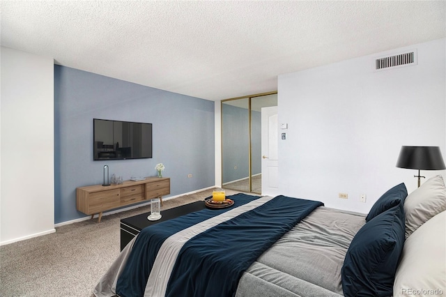 carpeted bedroom featuring a textured ceiling and a closet