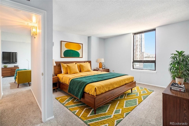 bedroom with a textured ceiling and light carpet