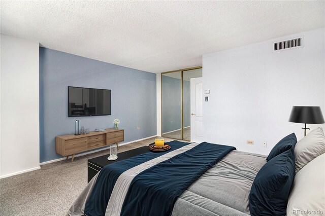 carpeted bedroom with baseboards, a closet, visible vents, and a textured ceiling