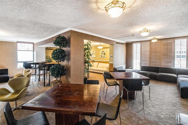 dining area featuring visible vents, crown molding, and a textured ceiling