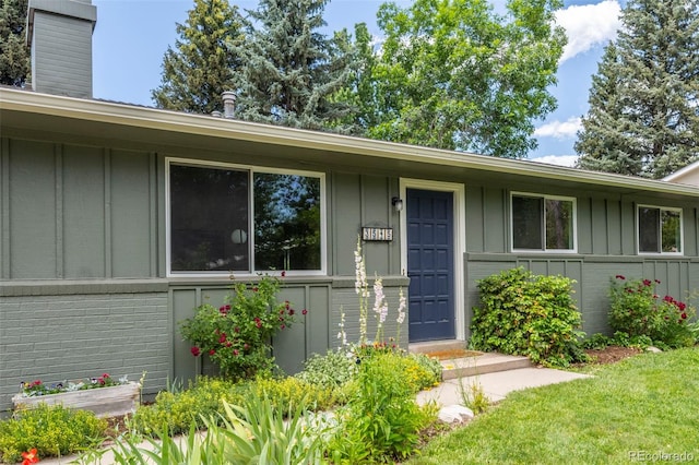 3545 Cloverleaf Dr, Boulder, CO 80304 - property entrance featuring board and batten siding, brick siding, and a chimney