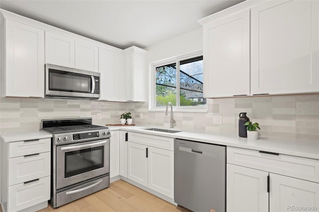 3545 Cloverleaf Dr, Boulder, CO 80304 - kitchen featuring stainless steel appliances, light countertops, white cabinets, light wood-type flooring, and tasteful backsplash