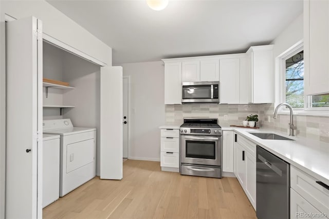 3545 Cloverleaf Dr, Boulder, CO 80304 - kitchen featuring stainless steel appliances, washer and clothes dryer, light wood-type flooring, white cabinetry, and open shelves