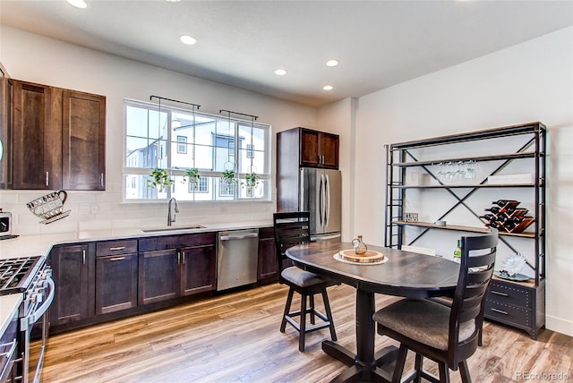 8361 Parkland St, Broomfield, CO 80021 - kitchen with light countertops, appliances with stainless steel finishes, a sink, light wood-type flooring, and backsplash