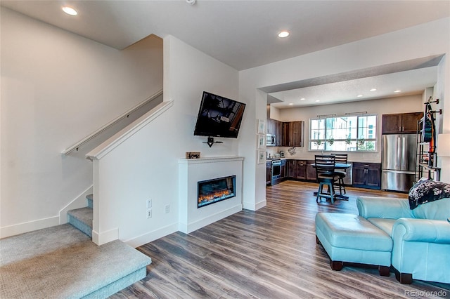 8361 Parkland St, Broomfield, CO 80021 - living room with stairway, recessed lighting, baseboards, a glass covered fireplace, and wood finished floors