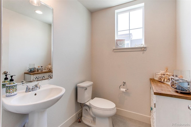 8361 Parkland St, Broomfield, CO 80021 - half bathroom with baseboards, toilet, tile patterned floors, and a sink