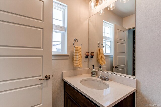 8361 Parkland St, Broomfield, CO 80021 - bathroom featuring plenty of natural light, a textured wall, and vanity