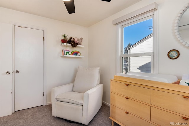 sitting room featuring ceiling fan and dark colored carpet