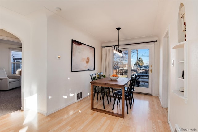 4920 Clay St, Denver, CO 80221 - dining space with arched walkways, baseboards, visible vents, and light wood-style floors