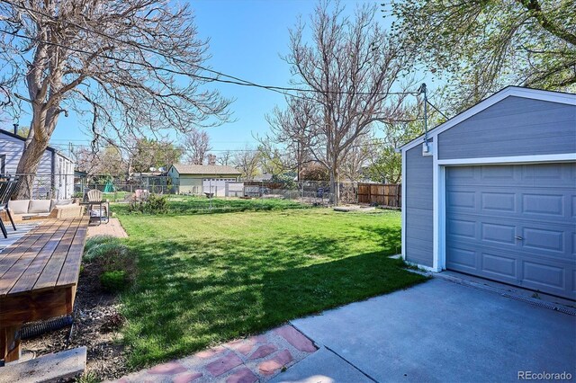 4920 Clay St, Denver, CO 80221 - view of yard with an outdoor structure, a fenced backyard, a garage, and driveway