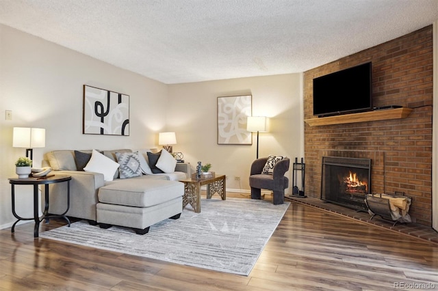 living room featuring hardwood / wood-style floors, a fireplace, and a textured ceiling