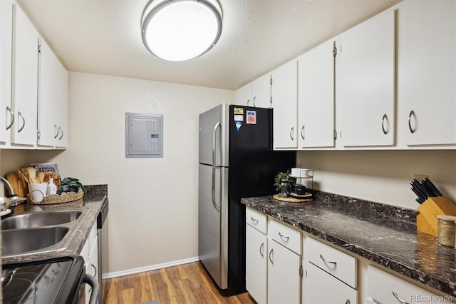 kitchen featuring appliances with stainless steel finishes, electric panel, sink, and white cabinets