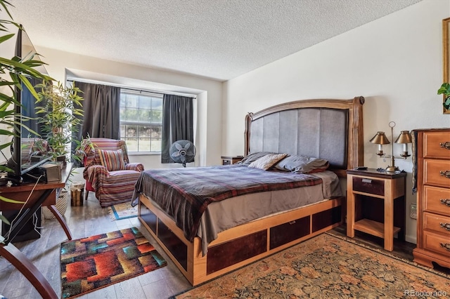 bedroom featuring a textured ceiling and light hardwood / wood-style flooring