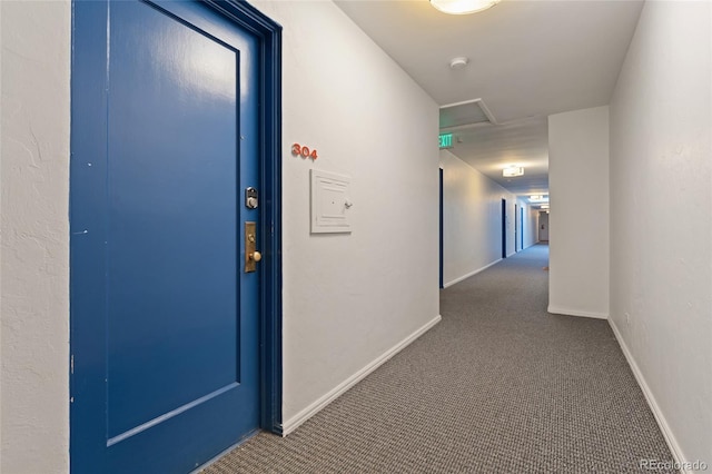 hallway featuring carpet flooring and baseboards