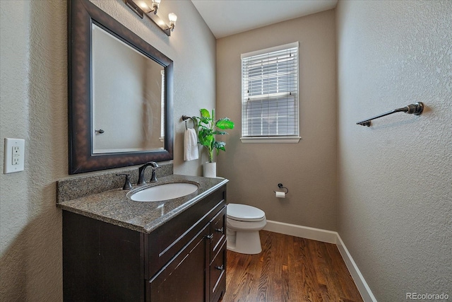 bathroom with vanity, toilet, and hardwood / wood-style floors