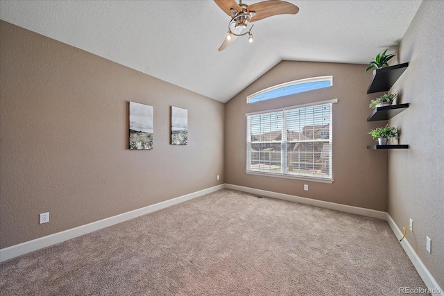 spare room with lofted ceiling, light colored carpet, ceiling fan, and a textured ceiling