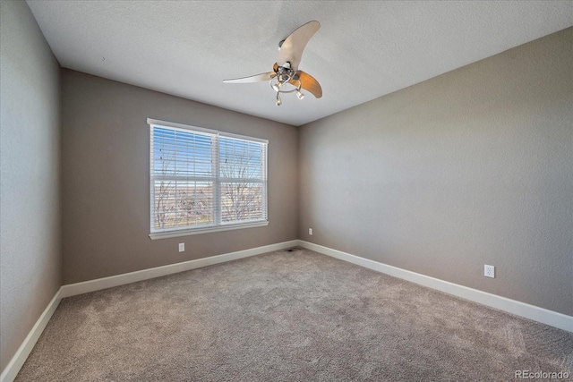 carpeted spare room with a textured ceiling and ceiling fan