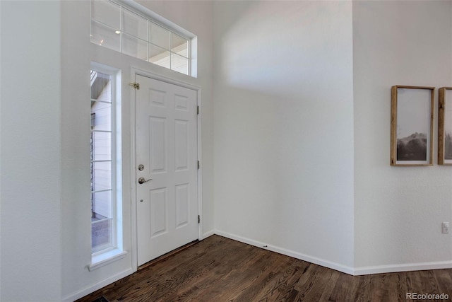 foyer entrance with dark wood-type flooring and baseboards