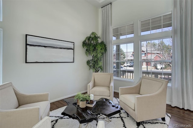 living area with baseboards and wood finished floors