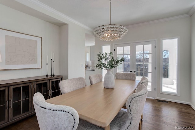 dining room featuring crown molding, a notable chandelier, visible vents, and dark wood-type flooring