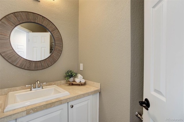 bathroom with vanity and a textured wall