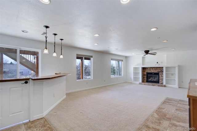 unfurnished living room featuring ceiling fan, light carpet, recessed lighting, a fireplace, and a textured ceiling